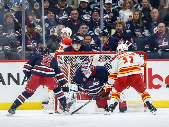 Winnipeg Jets goaltender Eric Comrie (1) saves the shot from Calgary Flames' Mikael Backlund (11) as Dylan DeMelo (2) in second period of the Jan. 18 game. The Flames won that game 3-1. (John Woods / The Canadian Press files)