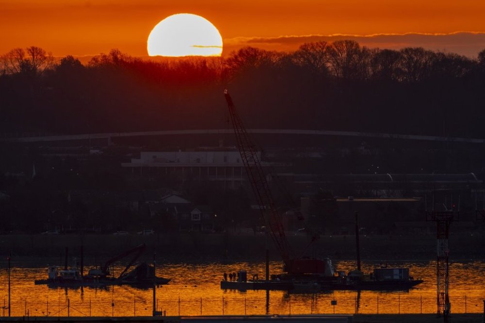 Salvage crews work near the wreckage site in the Potomac River of a mid-air collision between an American Airlines jet and a Black Hawk helicopter, at Ronald Reagan Washington National Airport, Tuesday, Feb. 4, 2025, in Arlington, Va. (AP Photo/Ben Curtis)