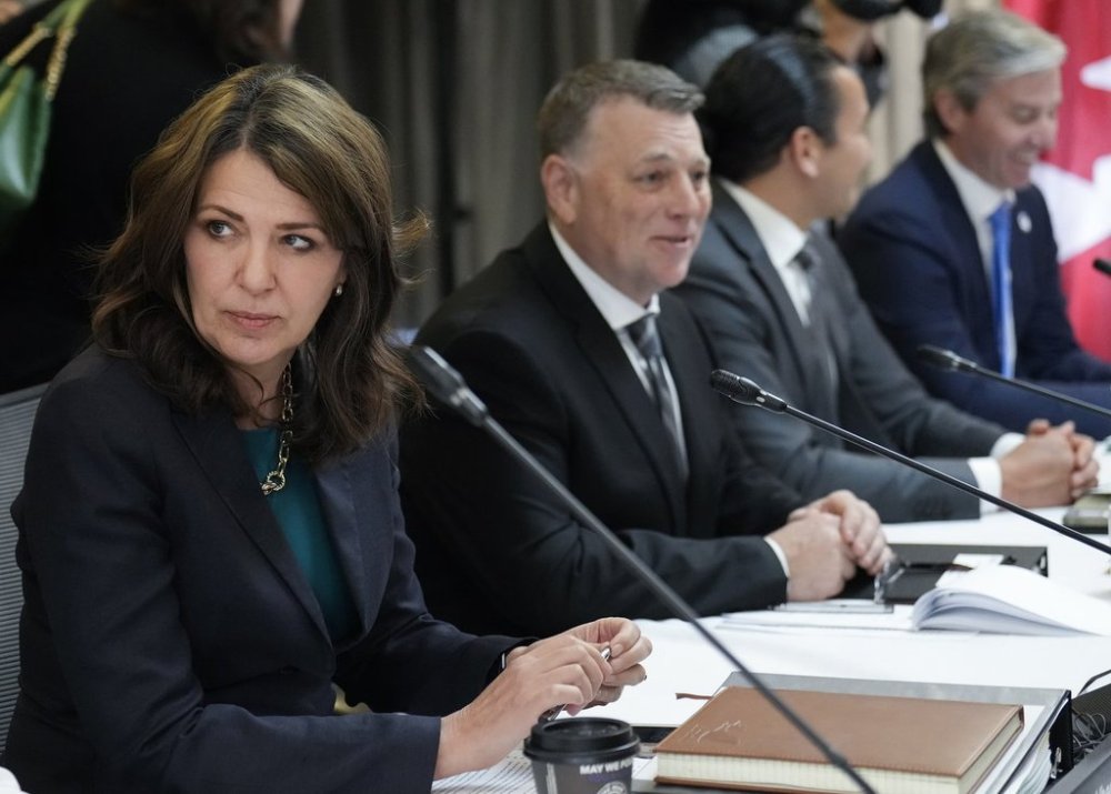 Alberta Premier Danielle Smith, left, talks with colleagues during the fall meetings of Canada's premiers hosted by Ontario in Toronto, Monday, Dec. 16, 2024. THE CANADIAN PRESS/Nathan Denette