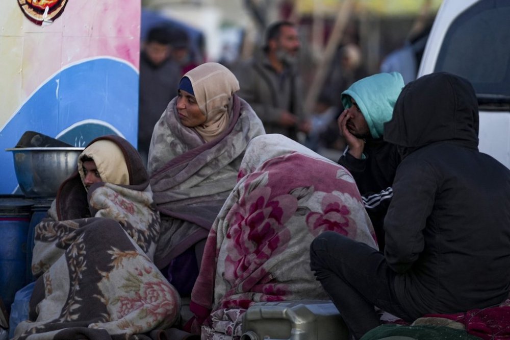 Displaced Palestinians gather with their belongings near a roadblock as they wait to return to their homes in the northern part of the Gaza Strip, Sunday, Jan. 26, 2025, days after the ceasefire deal between Israel and Hamas came into effect. (AP Photo/Abdel Kareem Hana)