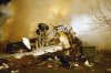 FILE - In this Feb. 12, 2009, file photo, the wreckage of Continental flight 3407 lies amid smoke at the scene after crashing into a suburban Buffalo home and erupting into flames. (AP Photo/Dave Sherman, File)