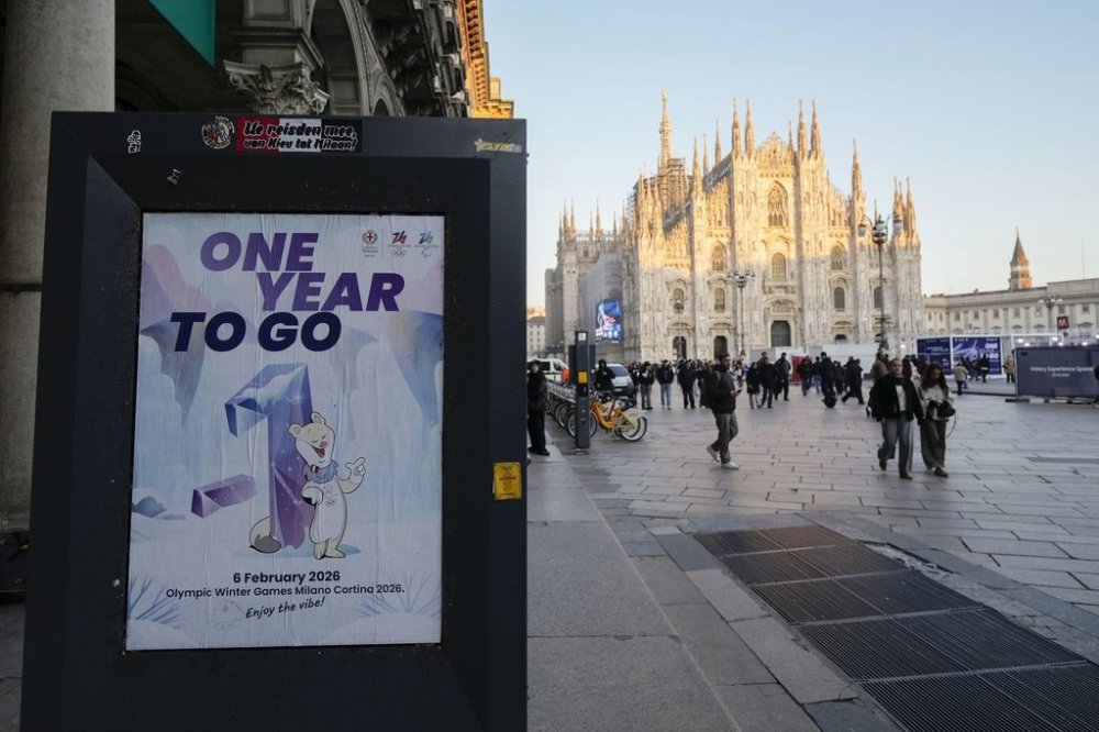 A billboard writing 'One Year To Go' for the Milano-Cortina Winter Olympics is displayed in front of the Duomo gothic cathedral, in Milan, Italy, Wednesday, Feb. 5, 2025. (AP Photo/Luca Bruno)