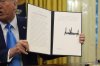President Donald Trump holds an executive order regarding withdrawing from the United Nationals Human Rights Council in the Oval Office of the White House, Tuesday, Feb. 4, 2025, in Washington. (AP Photo/Evan Vucci)