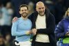 Manchester City's head coach Pep Guardiola celebrates with Bernardo Silva afte the Champions League opening phase soccer match between Manchester City and Club Brugge at the Etihad Stadium in Manchester, Wednesday, Jan. 29, 2025. (AP Photo/Dave Thompson)
