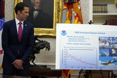 FILE - Neil Jacobs, assistant Secretary of Commerce for Environmental Observation and Prediction, stands next to a chart during a briefing with President Donald Trump on the 2020 hurricane season in the Oval Office of the White House in Washington on May 28, 2020. (AP Photo/Evan Vucci, File)