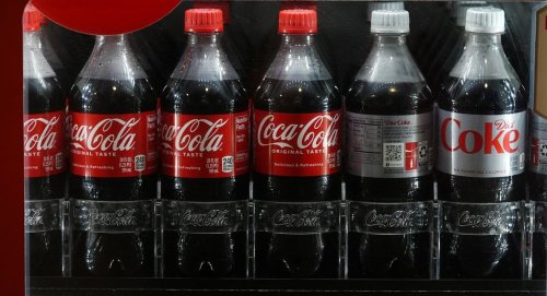 FILE - Bottles of Coac Cola chill in a refrigerated case in Coors Field before fans arrive to watch the Seattle Mariners face the Colorado Rockies, April 19, 2024, in Denver. (AP Photo/David Zalubowski, File)