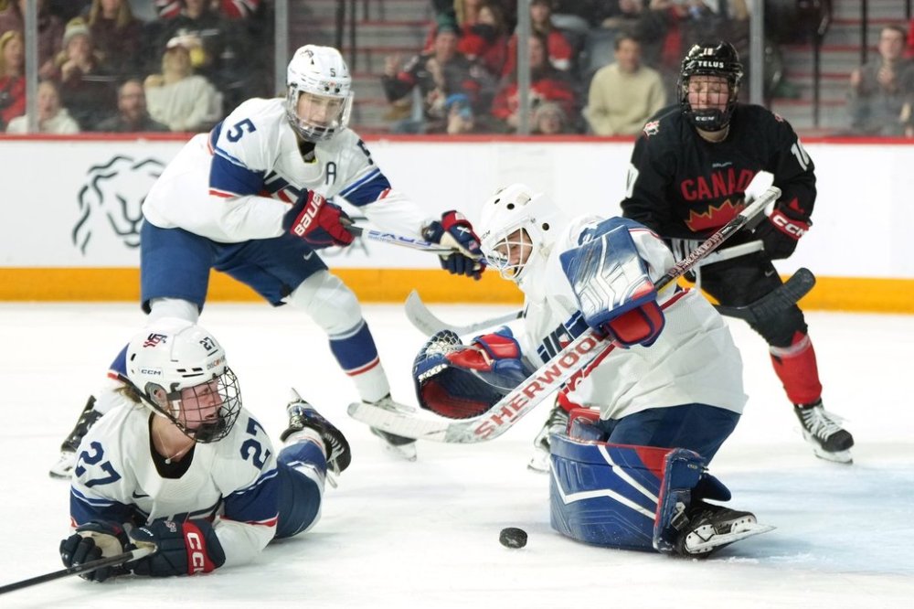 Team USA goaltender Gwyneth Philips makes a save in front of teammates Taylor Heise, left, and Megan Keller as Team Canada's Sarah Fillier, right, looks for a rebound during the second period of Rivalry Series hockey action in Halifax on Thursday, Feb. 6, 2025. THE CANADIAN PRESS/Darren Calabrese