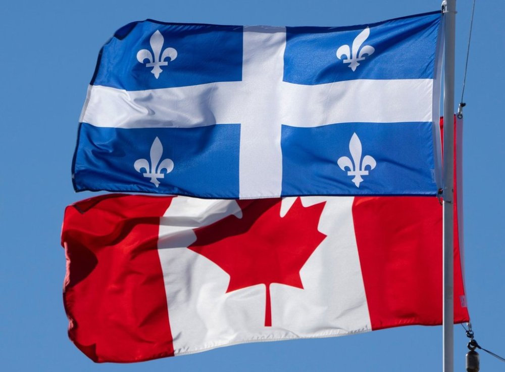 The flags of Canada and Quebec fly in Gatineau, Que., Monday, Nov. 1, 2021. THE CANADIAN PRESS/Adrian Wyld
