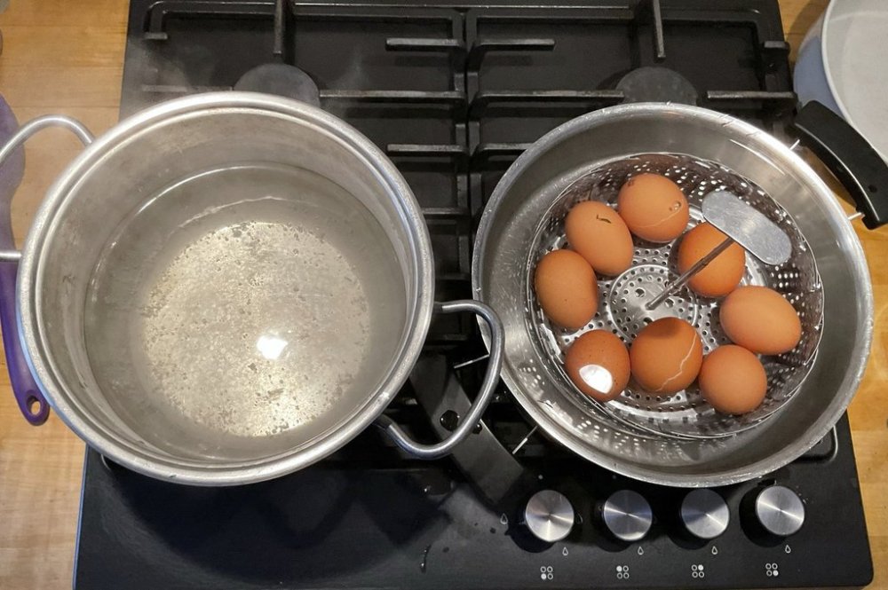 This photo provided by researchers in February 2025 shows two pots, one with boiling water, left, and the other with a basket of eggs in lukewarm water, in a new method of boiling eggs dubbed