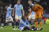 Real Madrid's Kylian Mbappe checks on the condition of Manchester City's Manuel Akanji after he picked up an injury during the Champions League playoff first leg soccer match between Manchester City and Real Madrid at the Etihad Stadium in Manchester, England, Tuesday, Feb. 11, 2025. (AP Photo/Darren Staples)