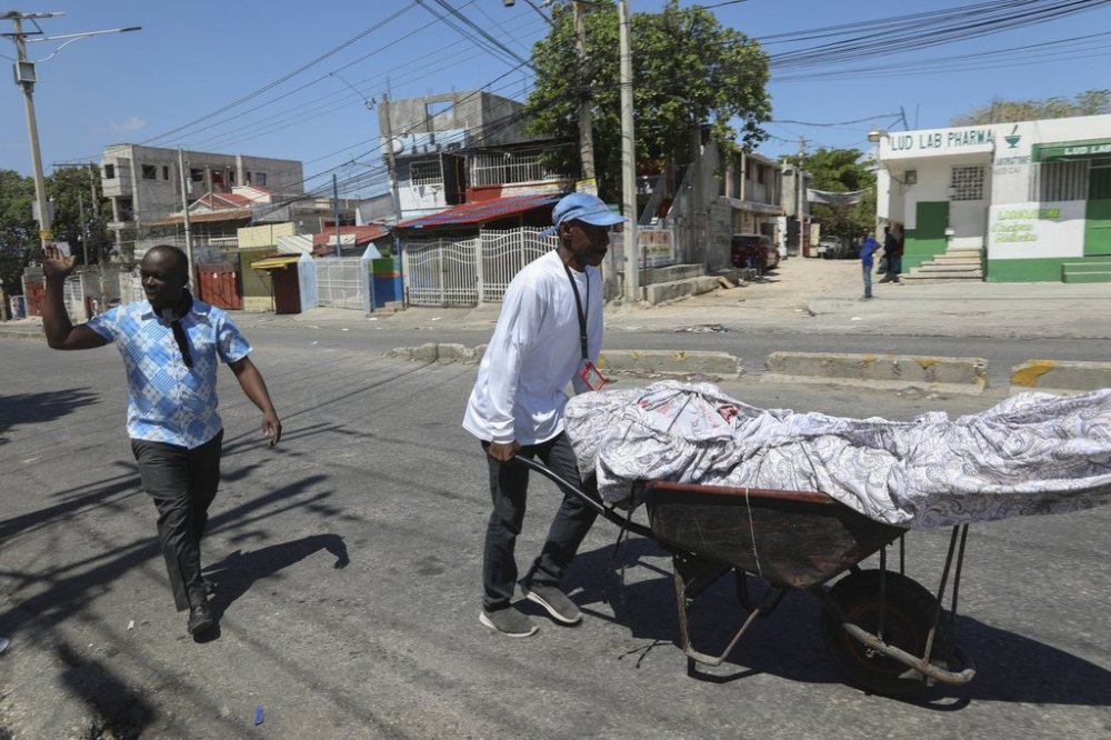 People transport the body of a man who died during a gang attack in the Delmas neighborhood of Port-au-Prince, Haiti, Tuesday, Feb. 25, 2025. (AP Photo/Odelyn Joseph)
