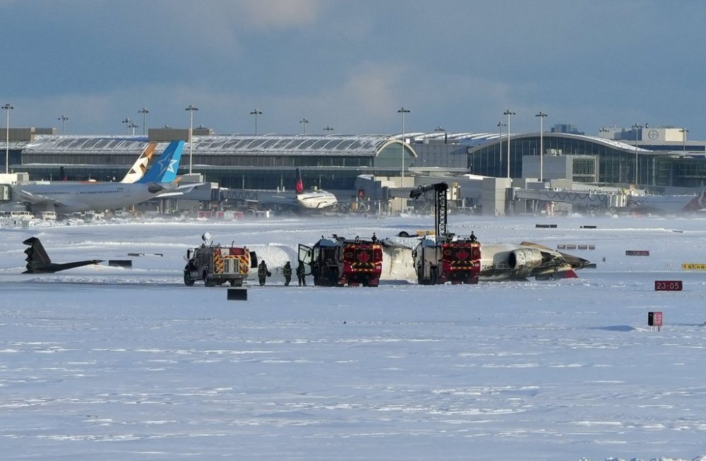 Pearson International Airport firefighters work on an upside down Delta Air Lines plane, which was heading from Minneapolis to Toronto when it crashed on the runway, in Toronto, Monday, Feb. 17, 2025. THE CANADIAN PRESS/Teresa Barbieri