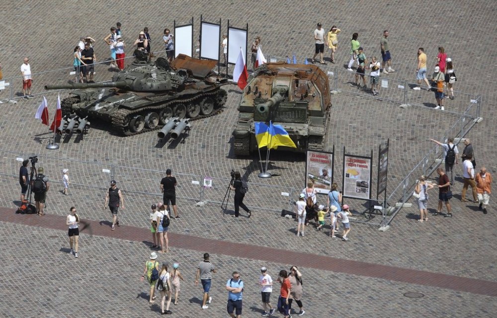 FILE - People visit an open-air exhibition of damaged and burnt-out Russian tanks and armored vehicles at the Castle Square, in Warsaw, Poland, June 27, 2022. (AP Photo/Michal Dyjuk, File)