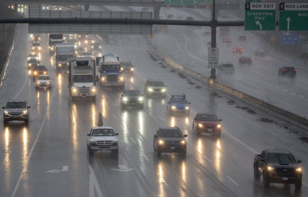 Traffic moves along highway 1 as heavy rains form an atmospheric river continue in Burnaby, B.C., Tuesday, Nov. 30, 2021. Metro Vancouver Transit Police say two men from Ontario have been arrested for taking part in a fake taxi scam that targeted people at universities and shopping centres in British Columbia's Lower Mainland. THE CANADIAN PRESS/Jonathan Hayward