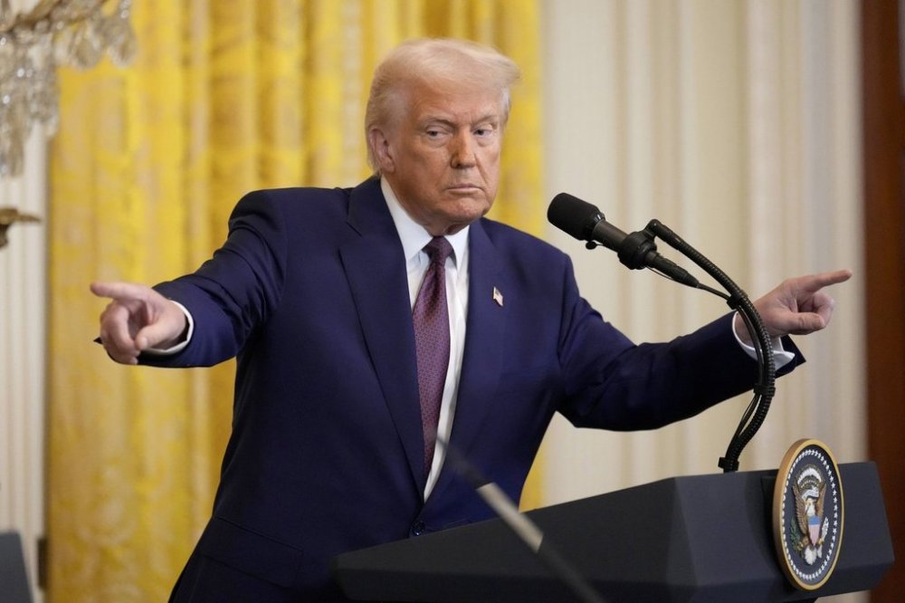 President Donald Trump points to a reporter and India's Prime Minister Narendra Modi during a news conference in the East Room of the White House, Thursday, Feb. 13, 2025, in Washington. (AP Photo/Ben Curtis)