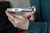 FILE - A woman holds up a dosage of Wegovy, a drug used for weight loss, at her home in Front Royal, Va., on March 1, 2024. (AP Photo/Amanda Andrade-Rhoades, File)