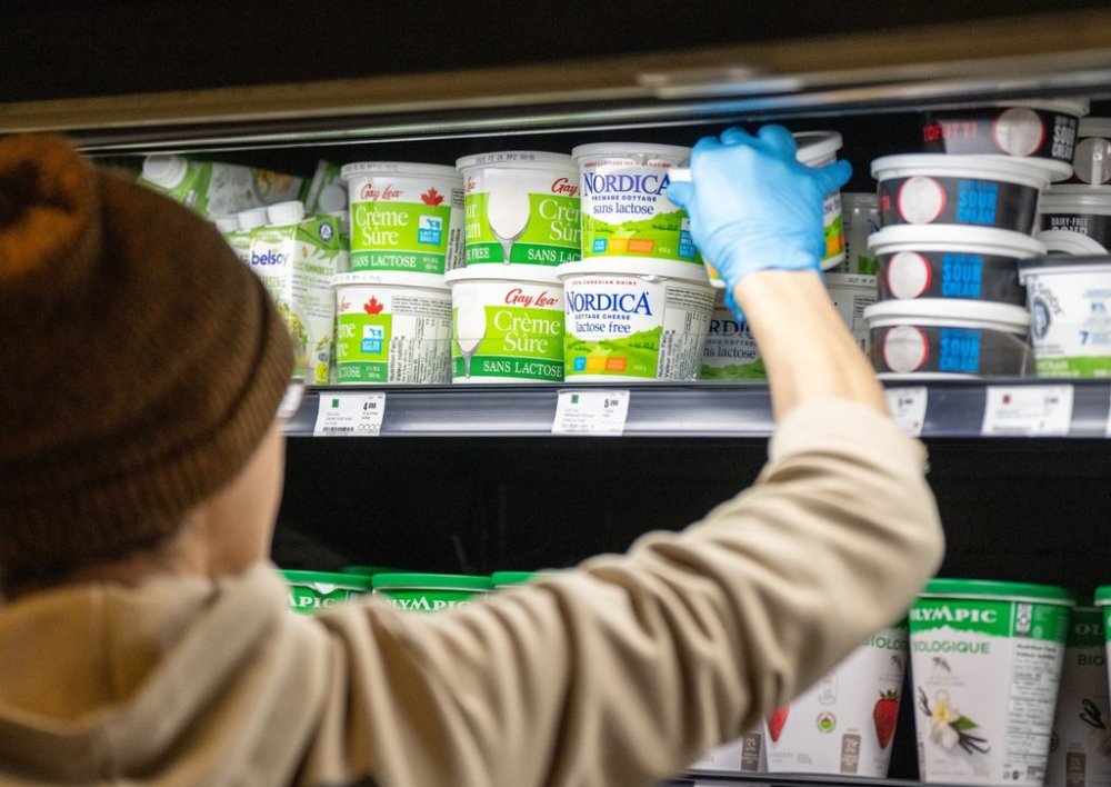 An grocery store employee restocks Canadian-made dairy products in Montreal on Tuesday, Feb. 4, 2025. THE CANADIAN PRESS/Christinne Muschi