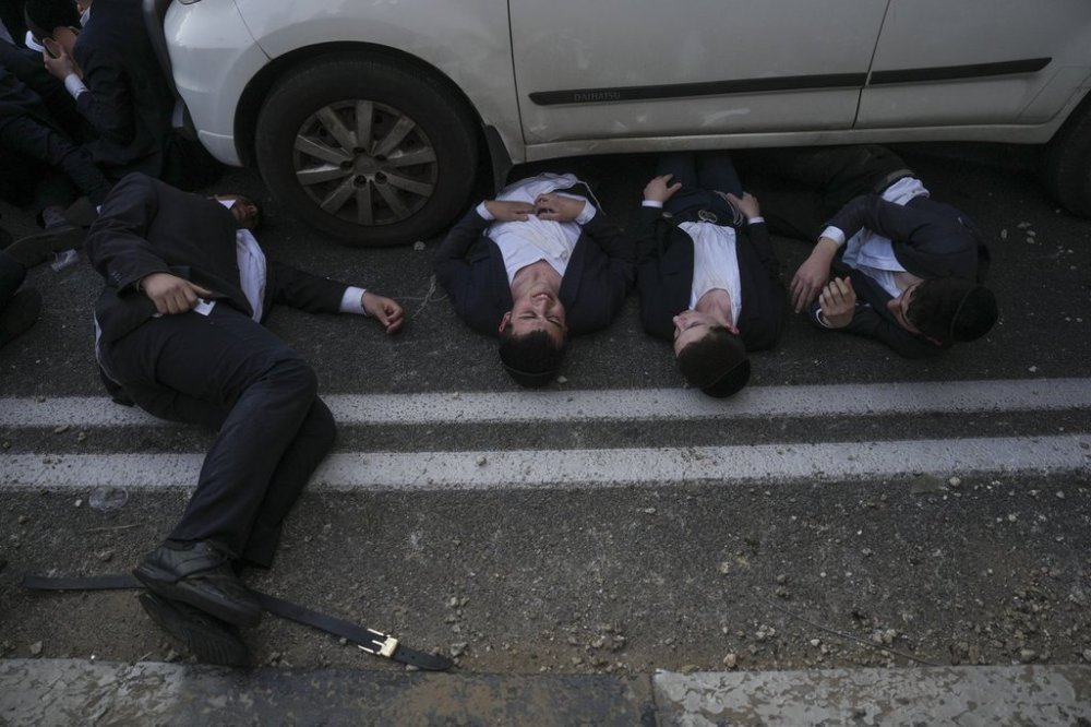 Ultra-Orthodox Jewish men blocking a highway during a protest against army recruitment in Bnei Brak, Israel, Sunday, March 2, 2025. (AP Photo/Ohad Zwigenberg)