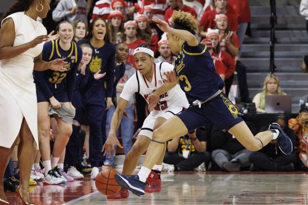 North Carolina State's Zoe Brooks, center left, handles the ball as Notre Dame's Hannah Hidalgo (3) defends during the second half of an NCAA college basketball game in Raleigh, N.C., Sunday, Feb. 23, 2025. (AP Photo/Ben McKeown)