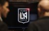 FILE - A sales representative gives a sales pitch to a customer interested in season tickets at the new sales office, featuring the logo for the LAFC (Los Angeles Football Club), in downtown Los Angeles, Feb. 17, 2017. (AP Photo/Richard Vogel)
