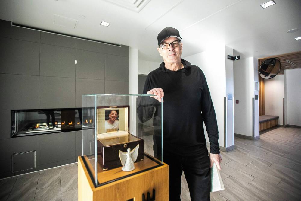 Mikaela MacKenzie / Free Press
                                Oake stands in the lobby of the Bruce Oake Recovery Centre next to a photo and the urn of his late son, after whom the centre is named.