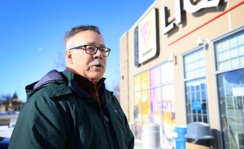 RUTH BONNEVILLE / FREE PRESS Local Tariffs US Booze Streeter Henry Schroeder responds to questions from the media about Tariffs on U.S. Booze outside the Liquor Mart at Portage & Ainslie Liquor store Monday. Feb 3rd, 2025