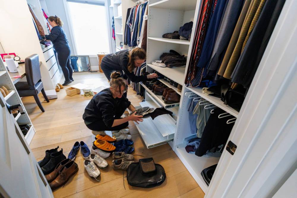 Sara Verwymeren (centre) and members of her staff at Three Pines Organizing work on a client’s walk-in closet. Verwymeren founded the Winnipeg-headquartered in-home organizing company in 2019. (Mike Deal / Free Press)