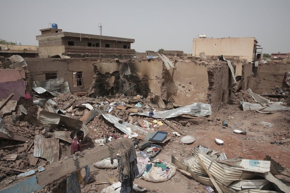 FILE - A man walks by a house hit in recent fighting in Khartoum, Sudan, an area torn by fighting between the military and the notorious paramilitary Rapid Support Forces, on April 25, 2023. (AP Photo/Marwan Ali, File)