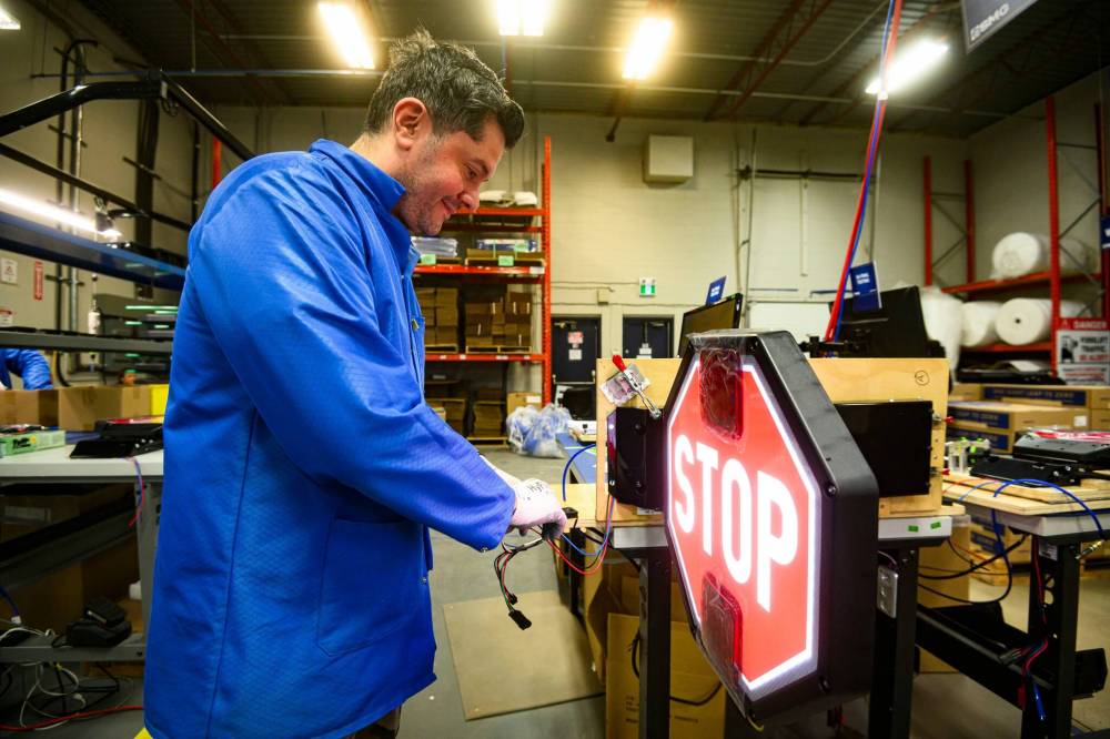 MIKE SUDOMA / FREE PRESS
Production worker Eduardo Serrano tests a flip-out stop sign used on school buses.