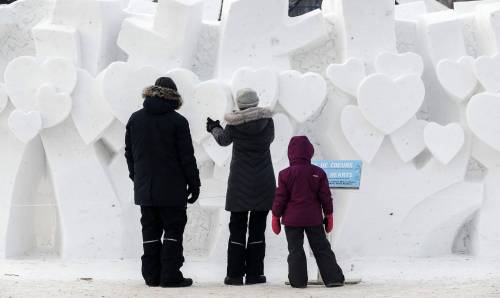 A family looks at the Forest Of Hearts snow sculpture at the Festival du Voyageur Sunday, February 16, 2025. (John Woods / Free Press)