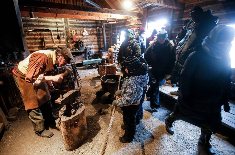 Visitors check out the blacksmith shop. (John Woods / Free Press)