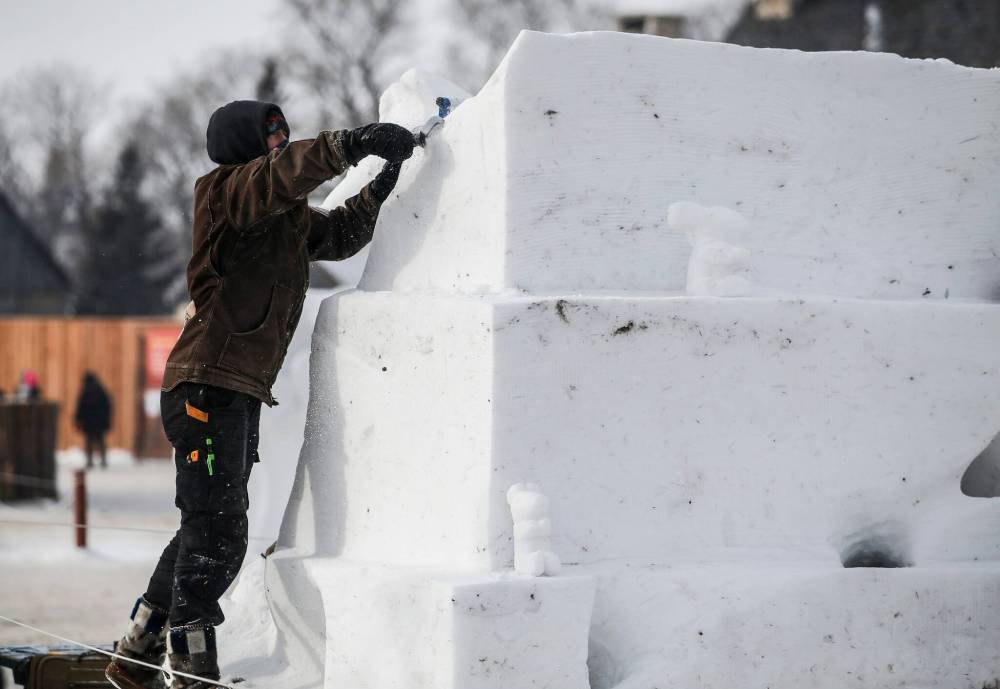 A snow sculptor adds the finsihing touches to a sculpture. (John Woods / Free Press)