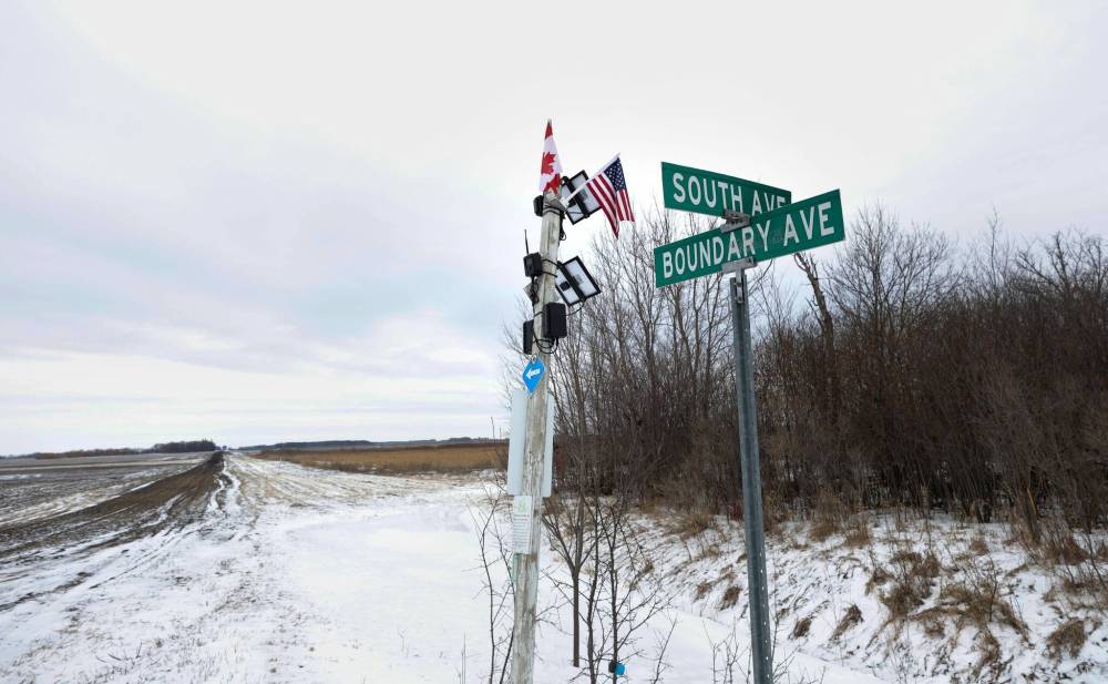RUTH BONNEVILLE / FREE PRESS FILES
                                Marker post with Canada and U.S. flags — and monitors — in Emerson.