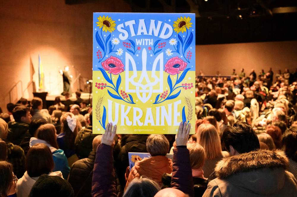 MIKE SUDOMA / FREE PRESS
Attendees hold up signs during the ceremony.