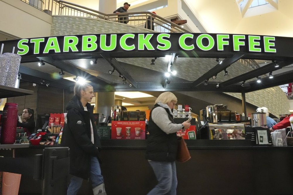 FILE - Shoppers at the Walden Galleria in Buffalo, NY, stop by the Starbucks kiosk on Saturday, Nov. 30, 2024. (AP Photo/Gene J. Puskar, File)