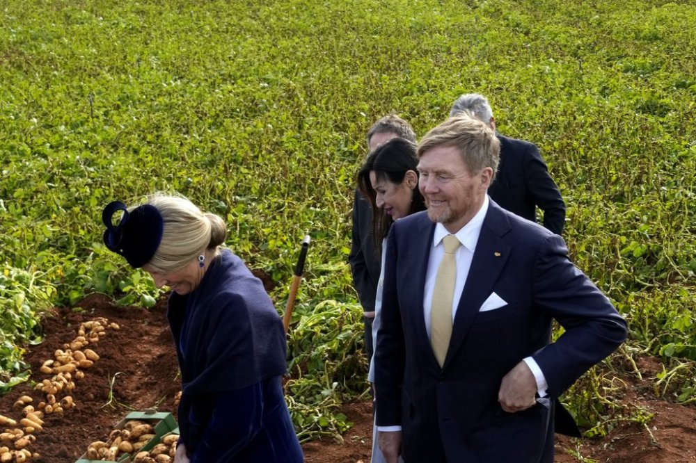 King Willem Alexander of the Netherlands, right, and Queen Maxima, walk in a potato field during their visit in Xylophagou village, Cyprus, on Tuesday, March 4, 2025. (AP Photo/Petros Karadjias)