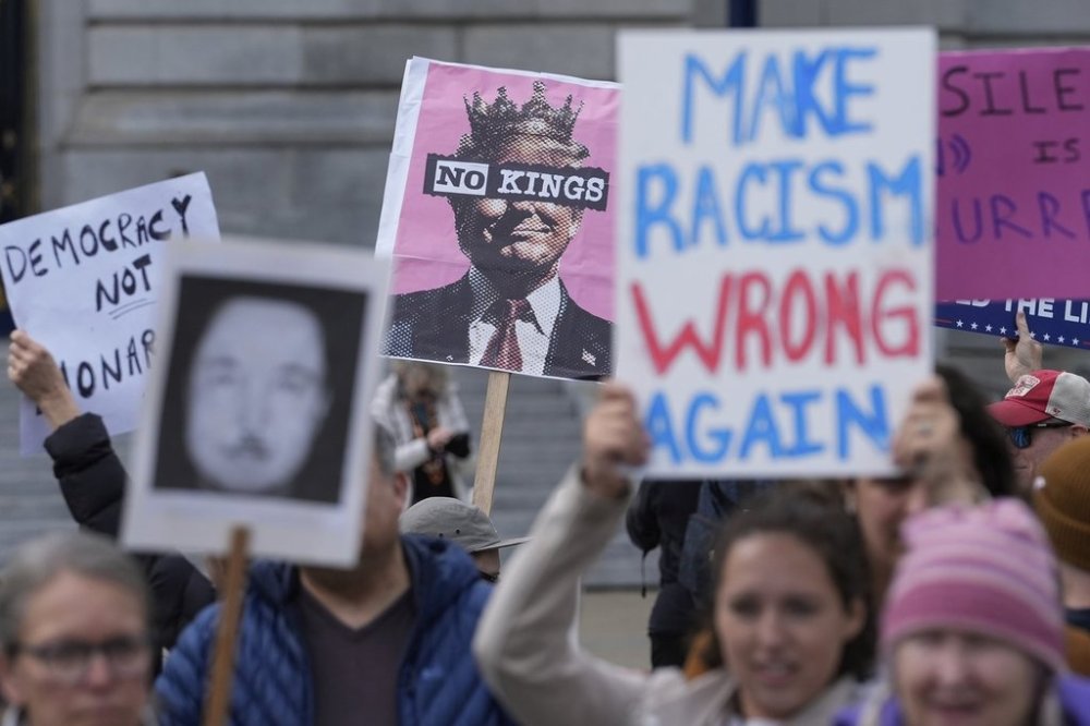People hold up signs to protest the Trump administration Tuesday, March 4, 2025, in San Francisco. (AP Photo/Godofredo A. Vásquez)