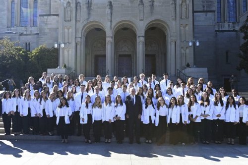 In this photo provided by The Catholic University, co-founder of The Carlyle Group, Bill Conway, center, who plans to give $1 billion to support nursing programs across the country, poses with nursing students from The Catholic University of America in Washington, Oct. 18, 2024, one of the 22 nursing schools that his nonprofit currently supports. (Patrick Ryan/The Catholic University of America via AP)