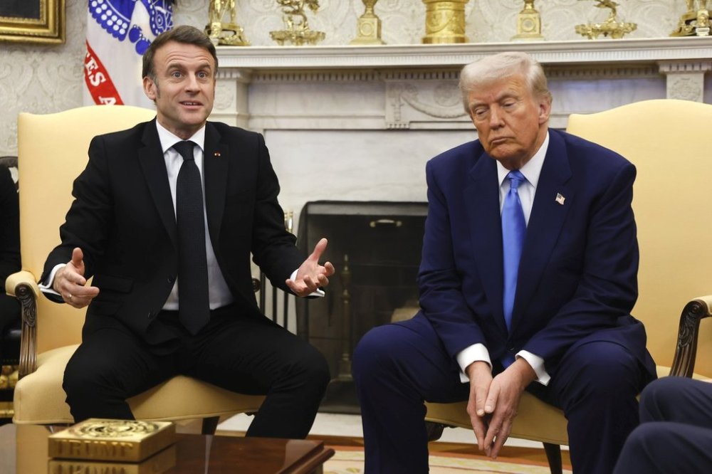 France's President Emmanuel Macron speaks as President Donald Trump listens during a meeting in the Oval Office of the White House in Washington, Monday, Feb. 24, 2025. (Ludovic Marin/Pool via AP)
