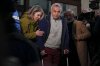 Calin Georgescu, the winner of Romania's first round of presidential election, annulled by the Constitutional Court, and his wife Cristela, leave the prosecutors office after being stopped in traffic and taken in for questioning in Bucharest, Romania, Wednesday, Feb. 26, 2025. (AP Photo/Vadim Ghirda)