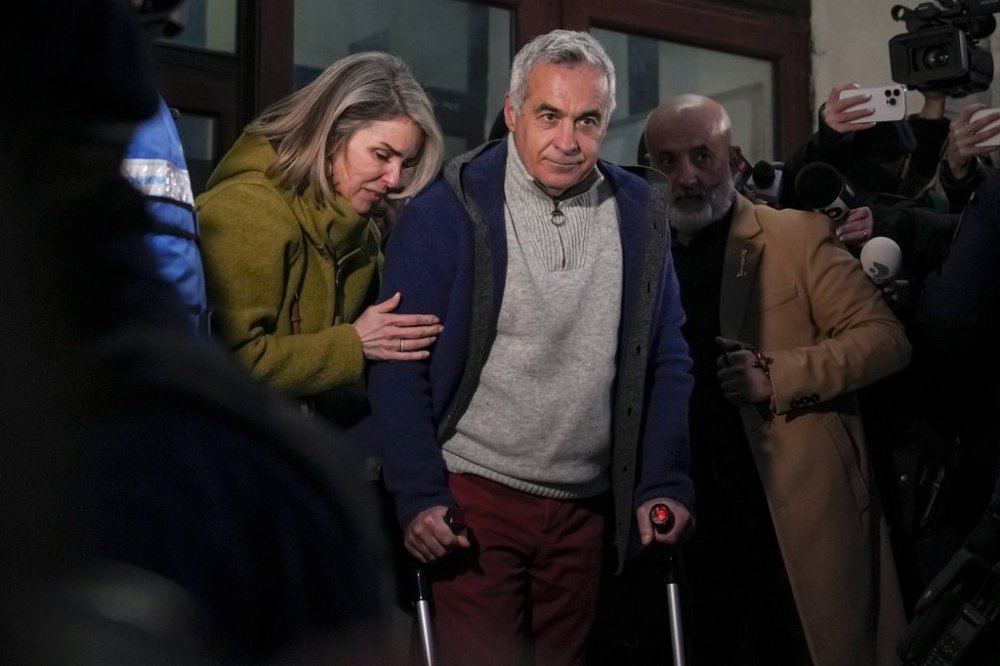 Calin Georgescu, the winner of Romania's first round of presidential election, annulled by the Constitutional Court, and his wife Cristela, leave the prosecutors office after being stopped in traffic and taken in for questioning in Bucharest, Romania, Wednesday, Feb. 26, 2025. (AP Photo/Vadim Ghirda)
