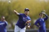 Los Angeles Dodgers' Shohei Ohtani, of Japan, warms up with other pitchers and catchers at the Dodgers baseball spring training facility, Tuesday, Feb. 11, 2025, in Phoenix. (AP Photo/Ross D. Franklin)