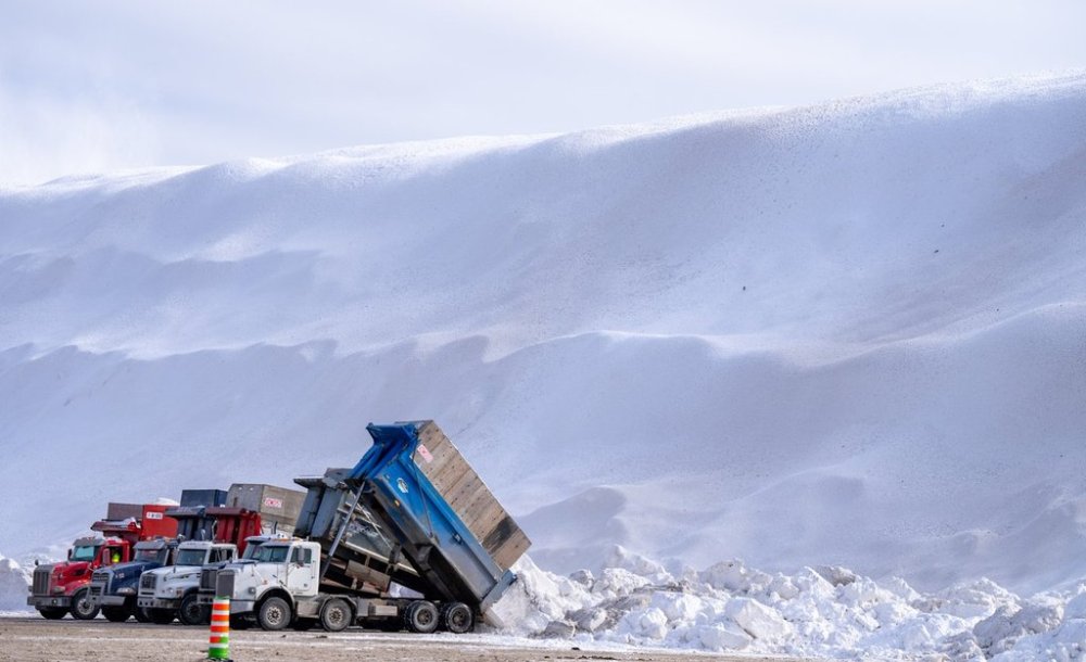 Trucks drop their loads of snow at the Angrignon snow deposit site in Montreal on Friday, Feb. 21, 2025. THE CANADIAN PRESS/Christinne Muschi