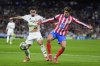 Real Madrid's Brahim Diaz, left, fights for the ball with Atletico Madrid's Reinildo Mandava during the Champions League round of 16 first leg soccer match between Real Madrid and Atletico Madrid at the Bernebeu stadium in Madrid, Spain, Tuesday, March 4, 2025. (AP Photo/Manu Fernandez)