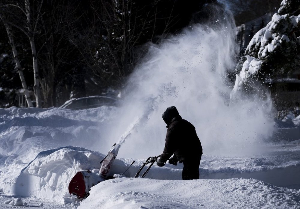 Environment Canada says much of southern Ontario will see heavy snowfall tonight and some regions could see up to 40 centimetres of snow, while northern Ontario braces for extreme cold temperatures. A person clears his driveway after a winter storm in Mississauga, Ont., on Tuesday, Jan. 18, 2022.THE CANADIAN PRESS/Nathan Denette