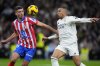 Atletico Madrid's Clement Lenglet vies for the ball with Real Madrid's Kylian Mbappe, right, during a Spanish La Liga soccer match between Real Madrid and Atletico Madrid at the Santiago Bernabeu stadium in Madrid, Saturday, Feb. 8, 2025. (AP Photo/Manu Fernandez)
