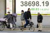 People stand in front of an electronic stock board showing Japan's Nikkei index at a securities firm Monday, Feb. 10, 2025, in Tokyo. (AP Photo/Eugene Hoshiko)