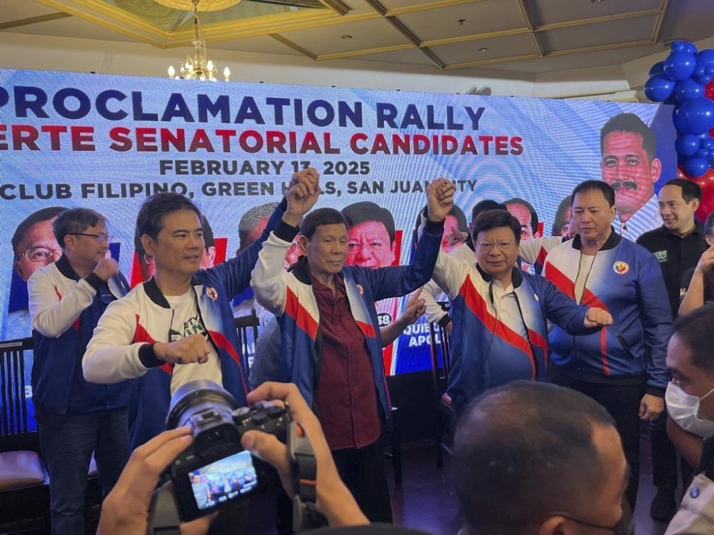 Former Philippine President Rodrigo Duterte, center, gestures with nine candidates under his political party PDP (Partido ng Demokratiko Pilipino) Laban, at the Club Filipino in metropolitan Manila, Thursday, Feb. 13, 2025. (AP Photo/Jim Gomez)
