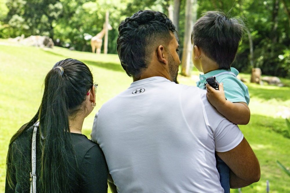 Two humanitarian parole beneficiaries, a mother and her son from Venezuela who were sponsored by Sandra McAnany, and the husband/father whom they reunited with enjoy the North Carolina Zoo, June 1, 2024, in Randolph County, NC. (Sandra McAnany via AP)