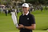 Ludvig Åberg, of Sweden, poses with the trophy after winning the Genesis Invitational golf tournament Sunday, Feb. 16, 2025, in San Diego. (AP Photo/Gregory Bull)
